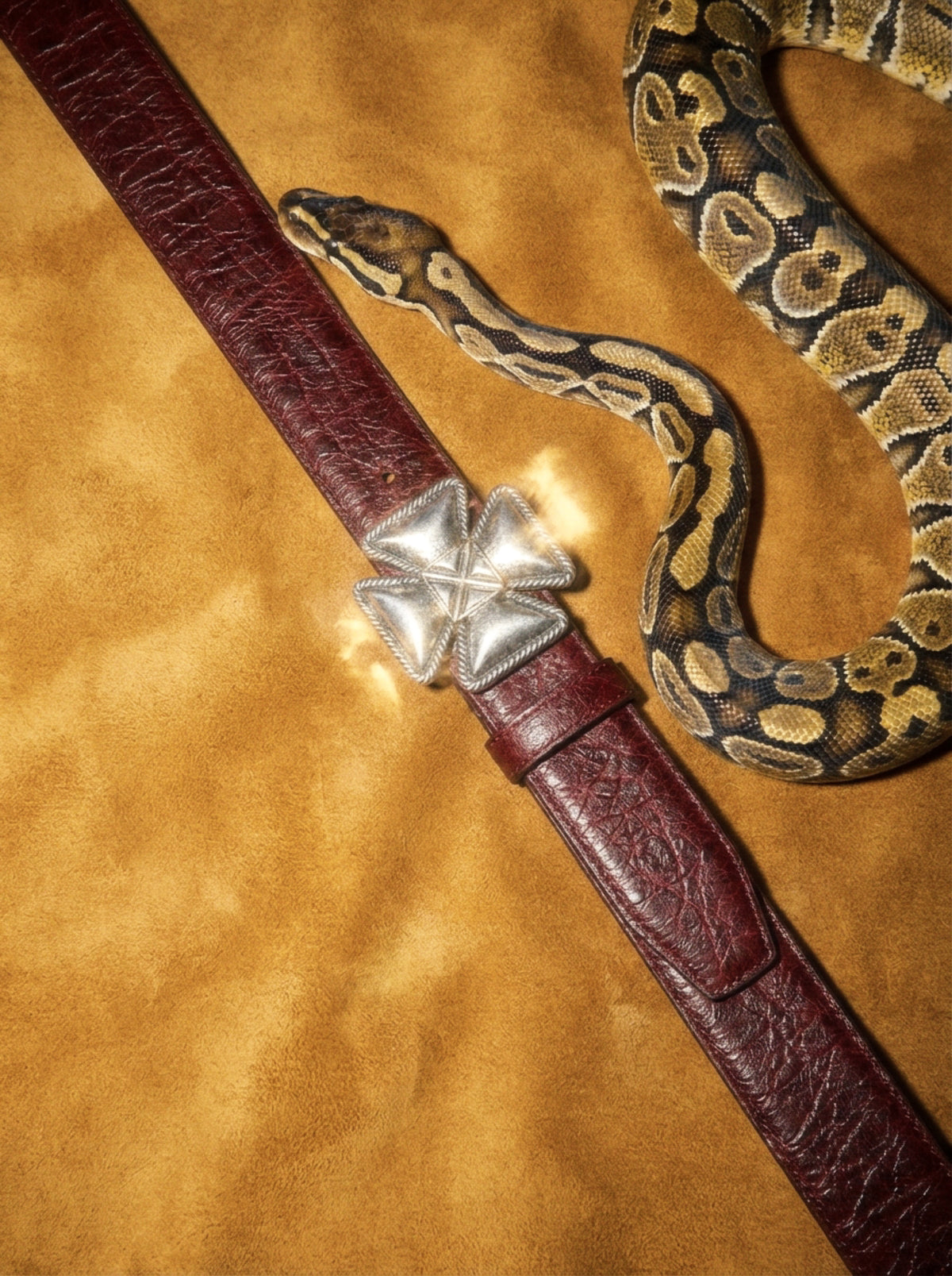 Oxblood leather belt with a silver cross buckle